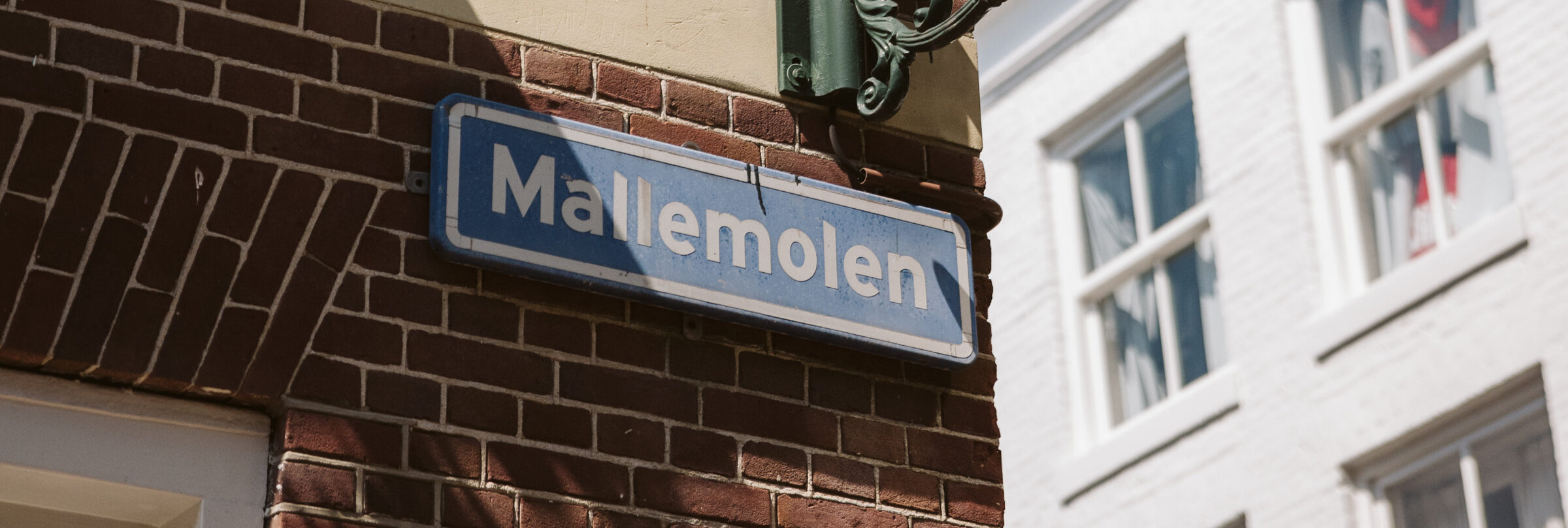 Straatnaambord Mallemolen aan een historische bakstenen gevel
